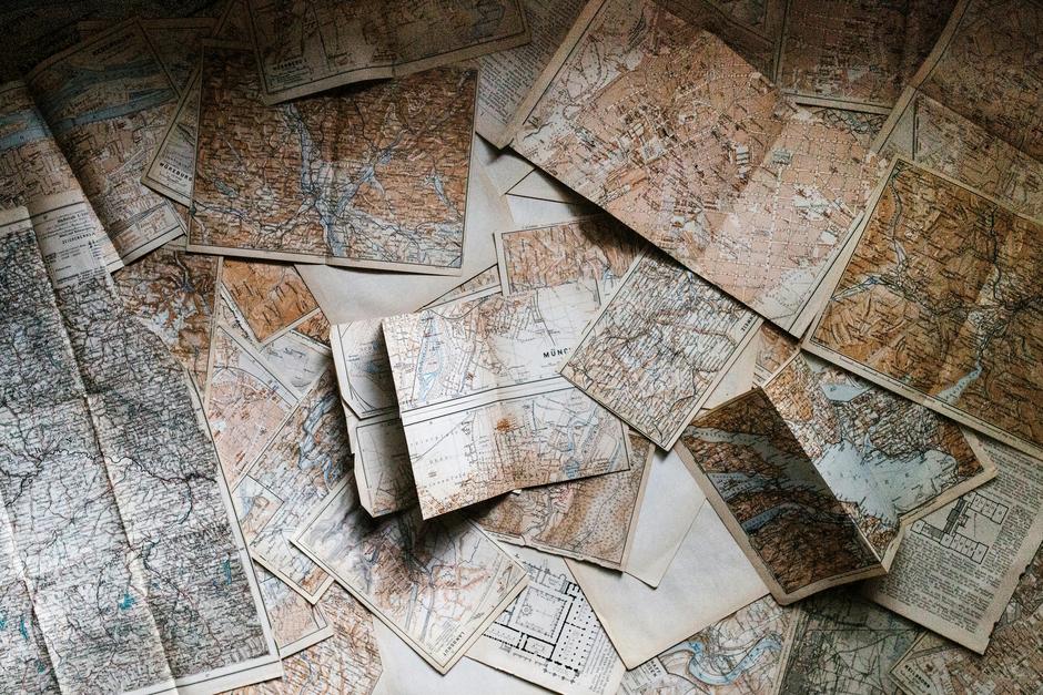 alt_text: Zgubiona mapa w lesie, otoczona drzewami i liśćmi, symbolizująca poszukiwanie.